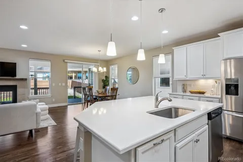a kitchen with a sink a stove a refrigerator and chairs