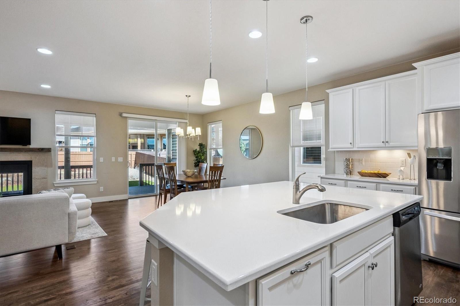 6667 Club Villa Road Parker, CO 80134 - Photo 8 of 50 a kitchen with a sink a stove a refrigerator and chairs