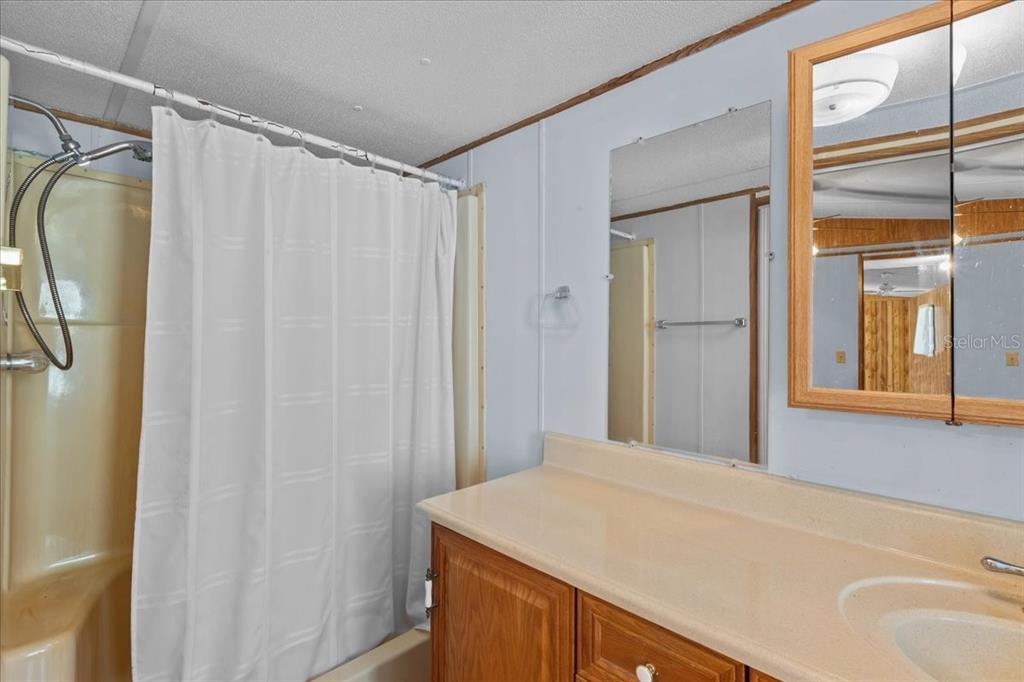 Undisclosed Address Bronson, FL 32621 - Photo 13 of 35 a bathroom with a shower curtain and a sink