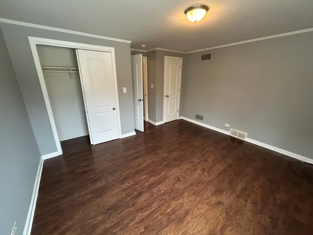 an empty room with wooden floor and entrance