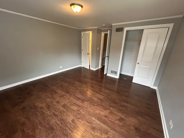 an empty room with wooden floor and closet