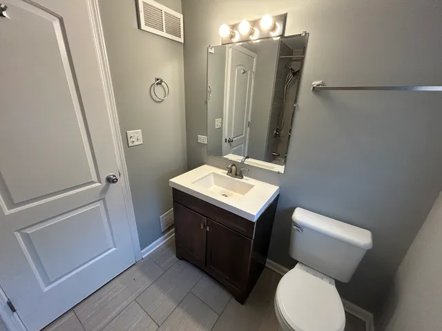 a bathroom with a toilet sink and mirror