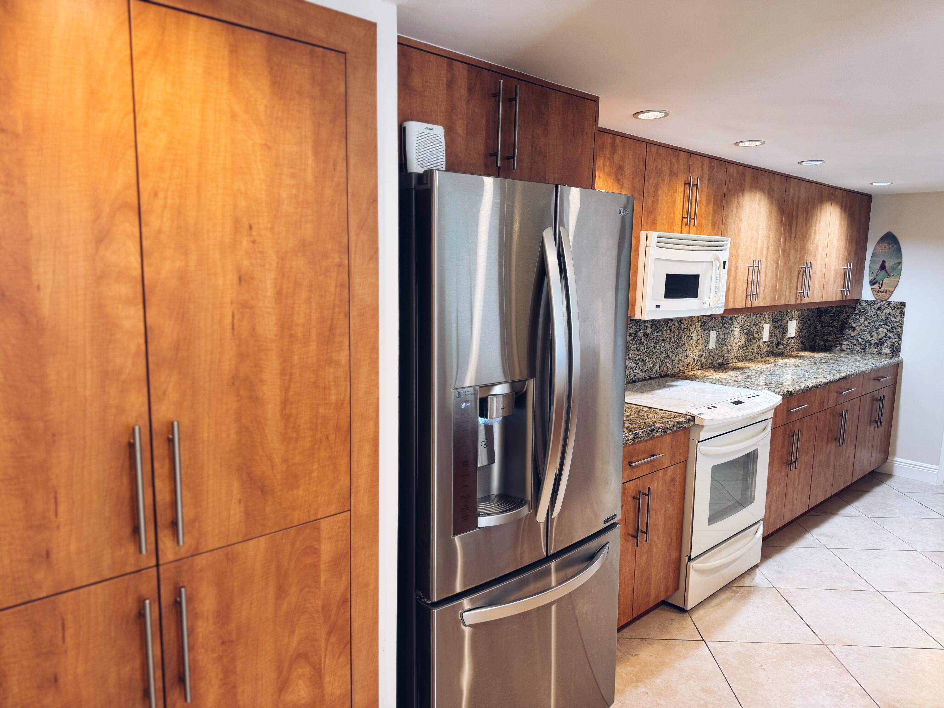 1915 Lavers Circle, Unit E209 Delray Beach, FL 33444 - Photo 11 of 20 a kitchen with stainless steel appliances a refrigerator and a stove top oven