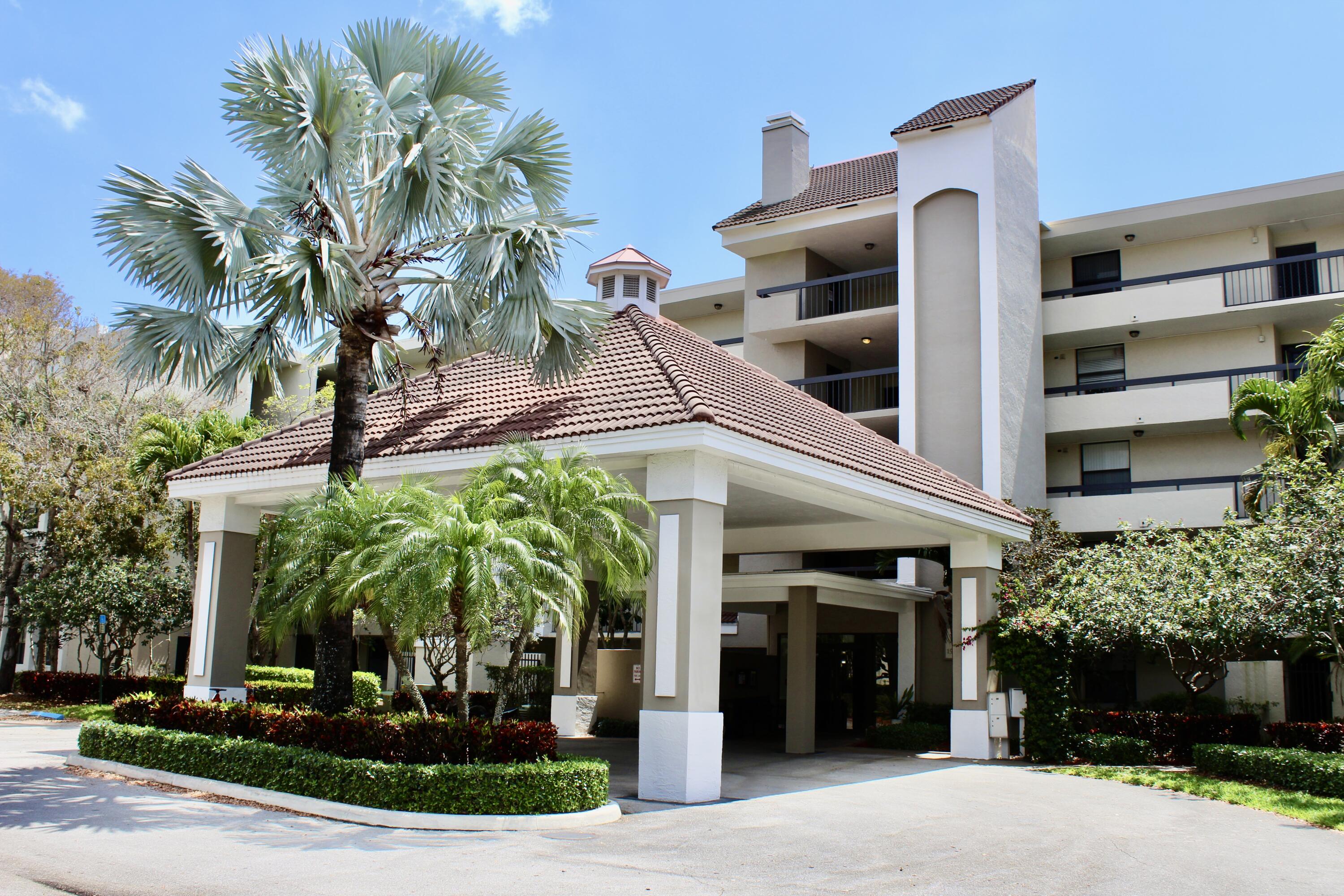 1915 Lavers Circle, Unit E209 Delray Beach, FL 33444 - Photo 19 of 20 a front view of a building with yellow lighting