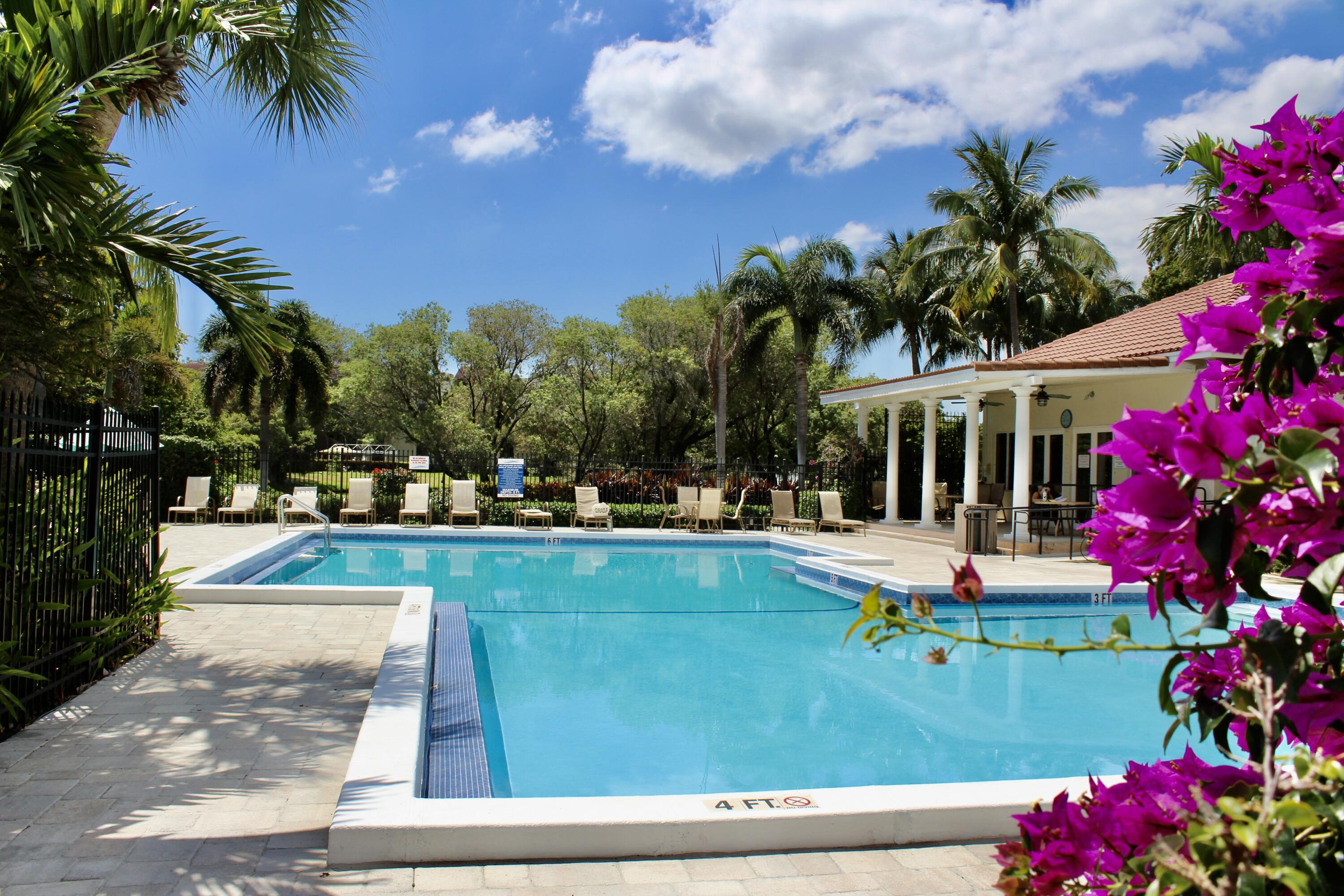 1915 Lavers Circle, Unit E209 Delray Beach, FL 33444 - Photo 2 of 20 a view of a swimming pool with a garden