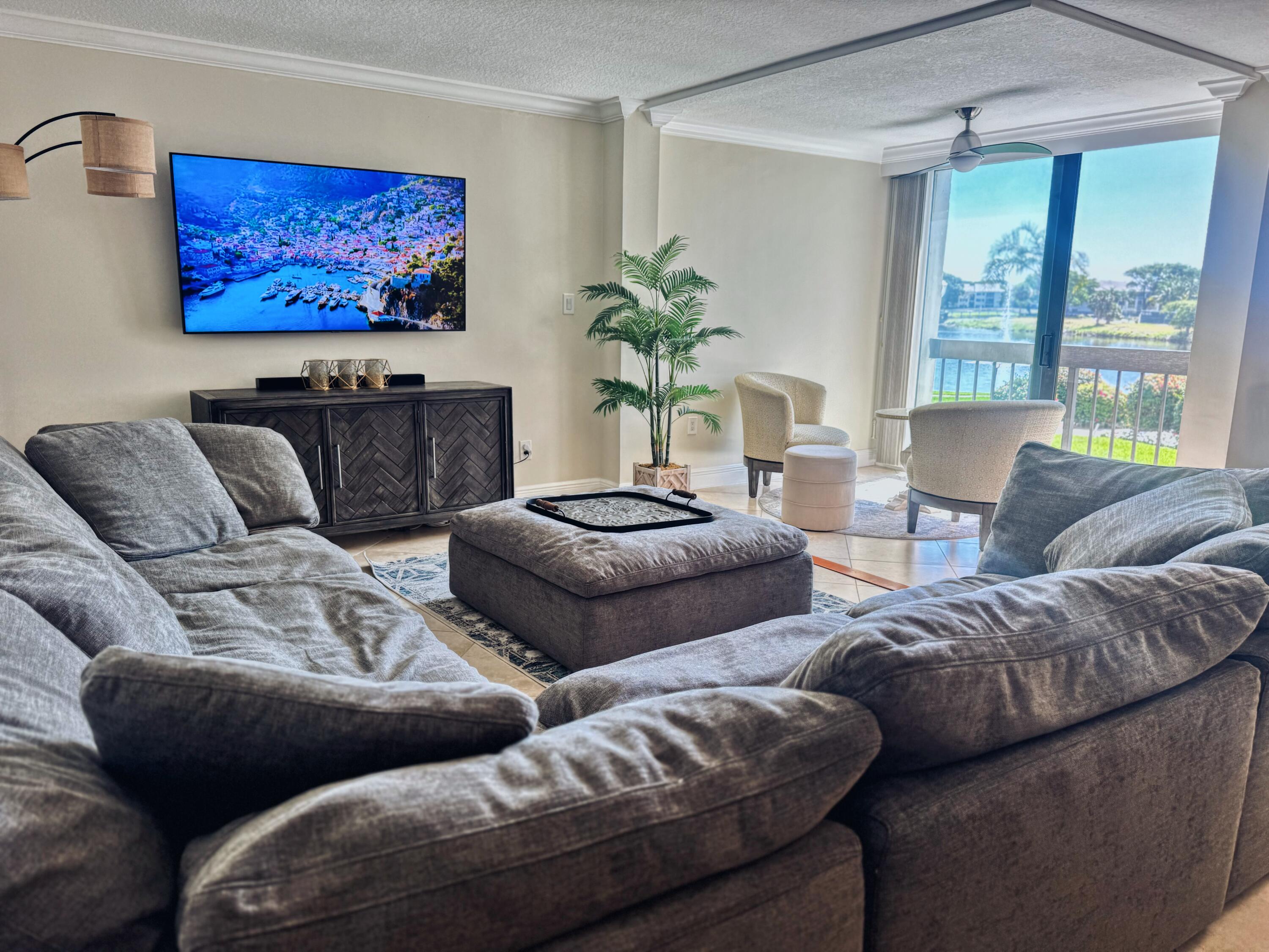 1915 Lavers Circle, Unit E209 Delray Beach, FL 33444 - Photo 9 of 20 a living room with furniture and a flat screen tv