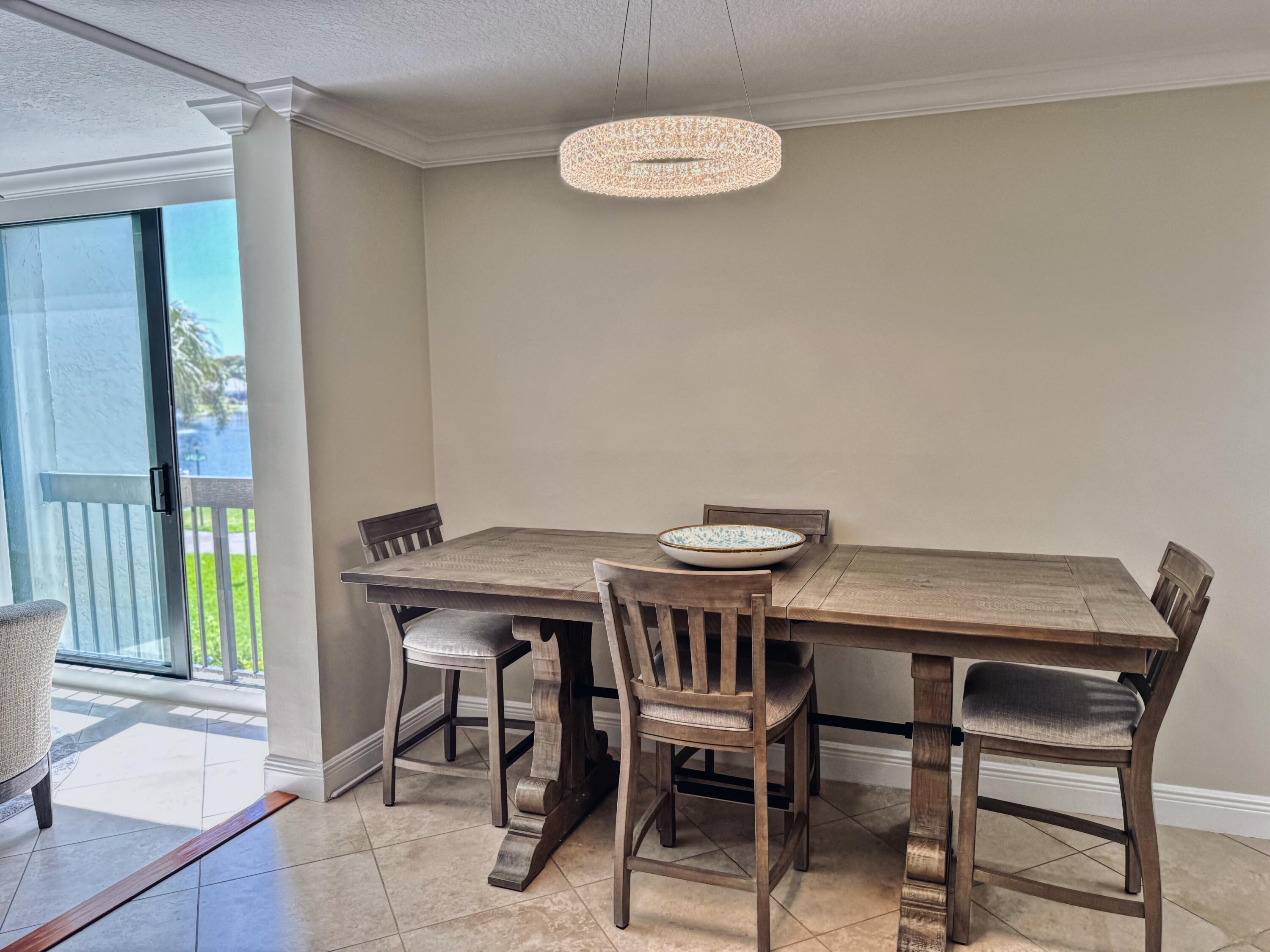 1915 Lavers Circle, Unit E209 Delray Beach, FL 33444 - Photo 10 of 20 a view of a dining room with furniture and a potted plant