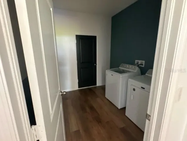 a utility room with a wooden floor washer and dryer