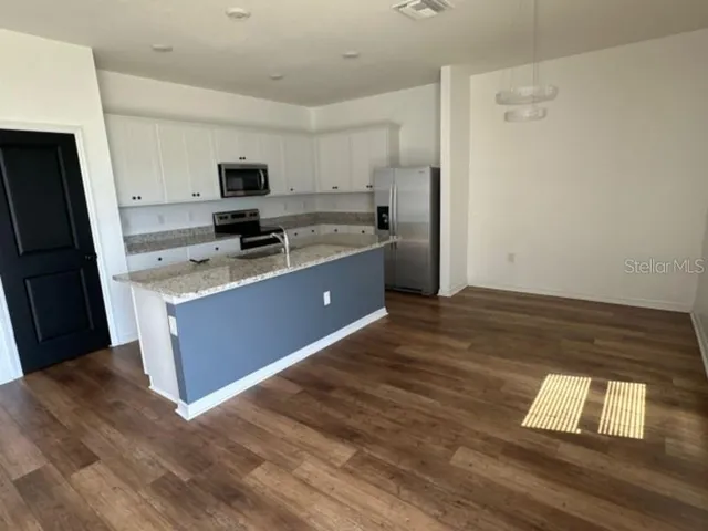 a kitchen with stainless steel appliances a refrigerator and a stove top oven