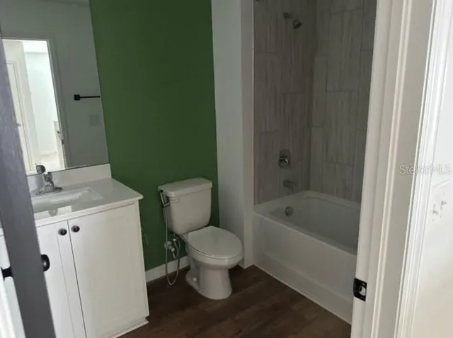 a white toilet sitting next to a bathroom sink and tub