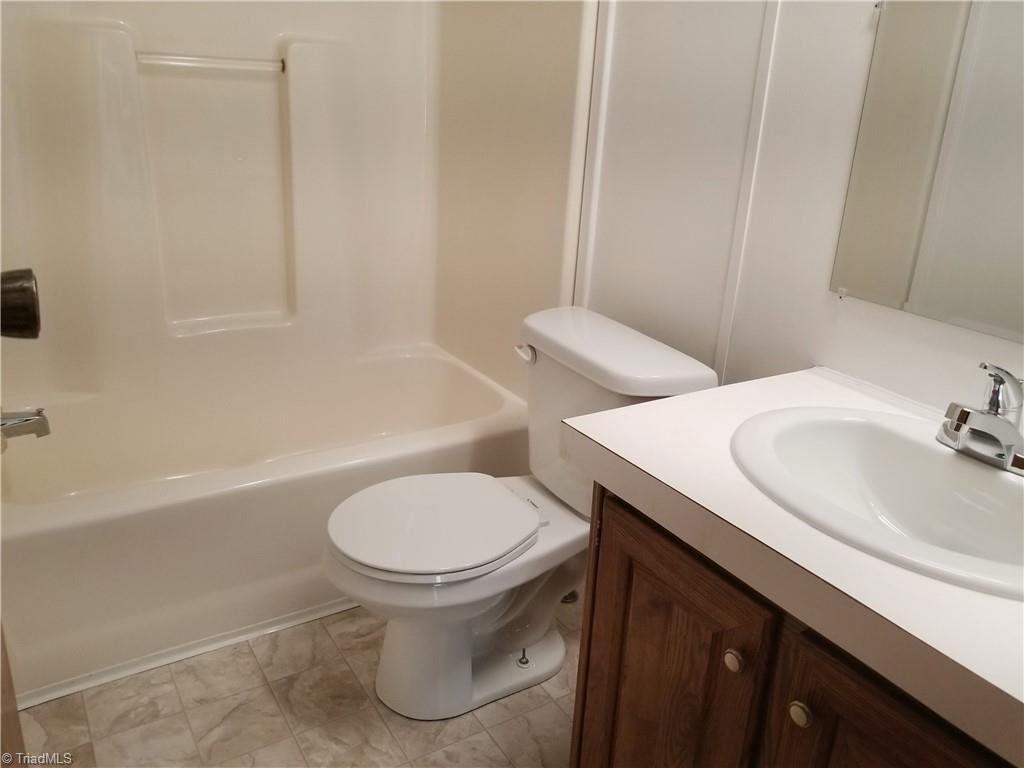 1309 Gordon Road Pinnacle, NC 27043 - Photo 25 of 41 Main bathroom with new vinyl flooring, new commode, new sink and fixtures, new shower fixture, all new LED light and light switches