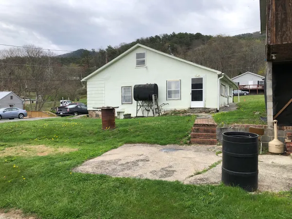 a view of a house with a yard and sitting area