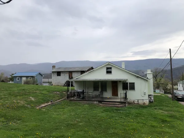 a front view of a house with a garden and trees