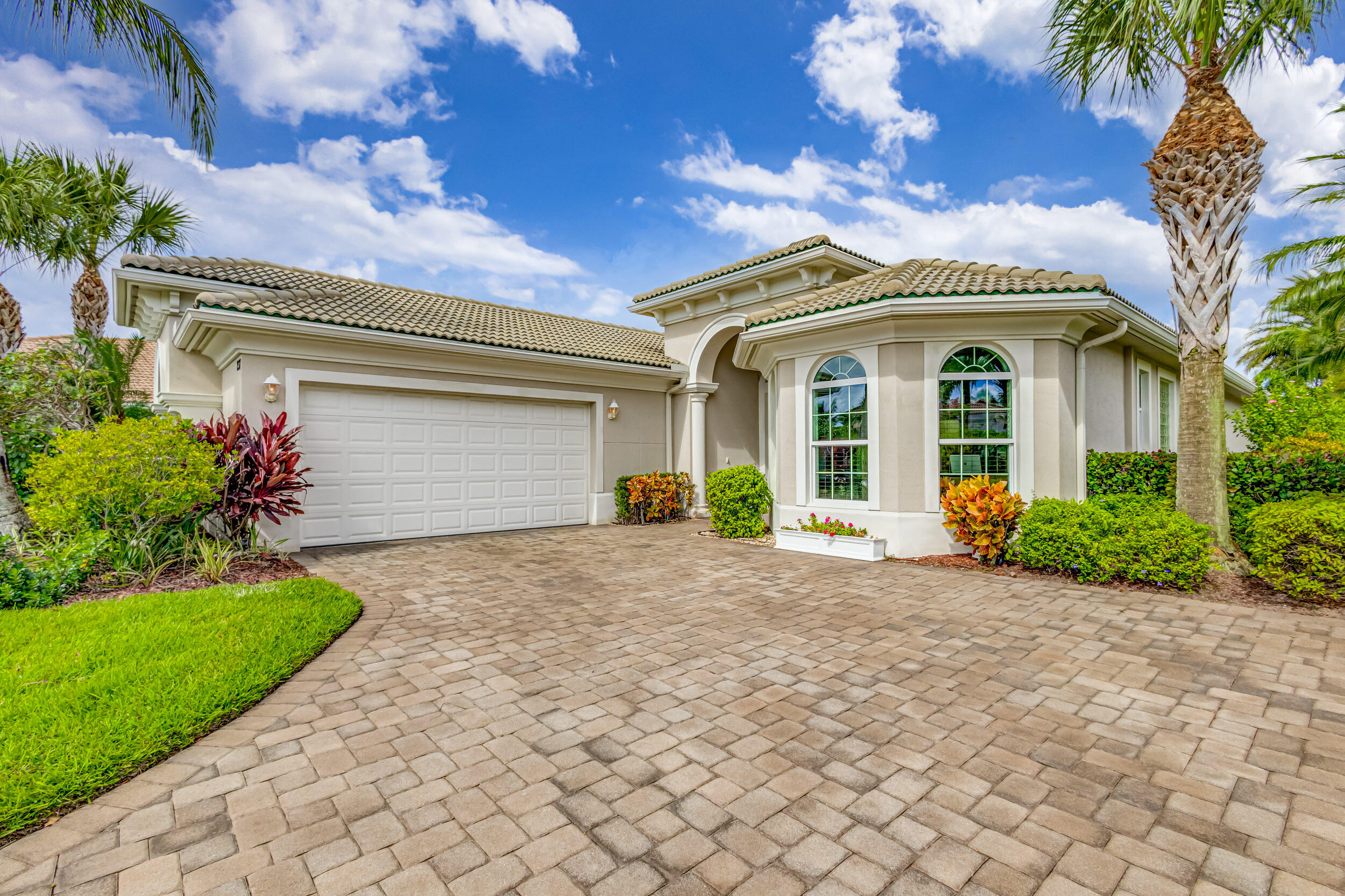 237 Carina Drive Jupiter, FL 33478 - Photo 12 of 73 a front view of a house with a yard and a garage