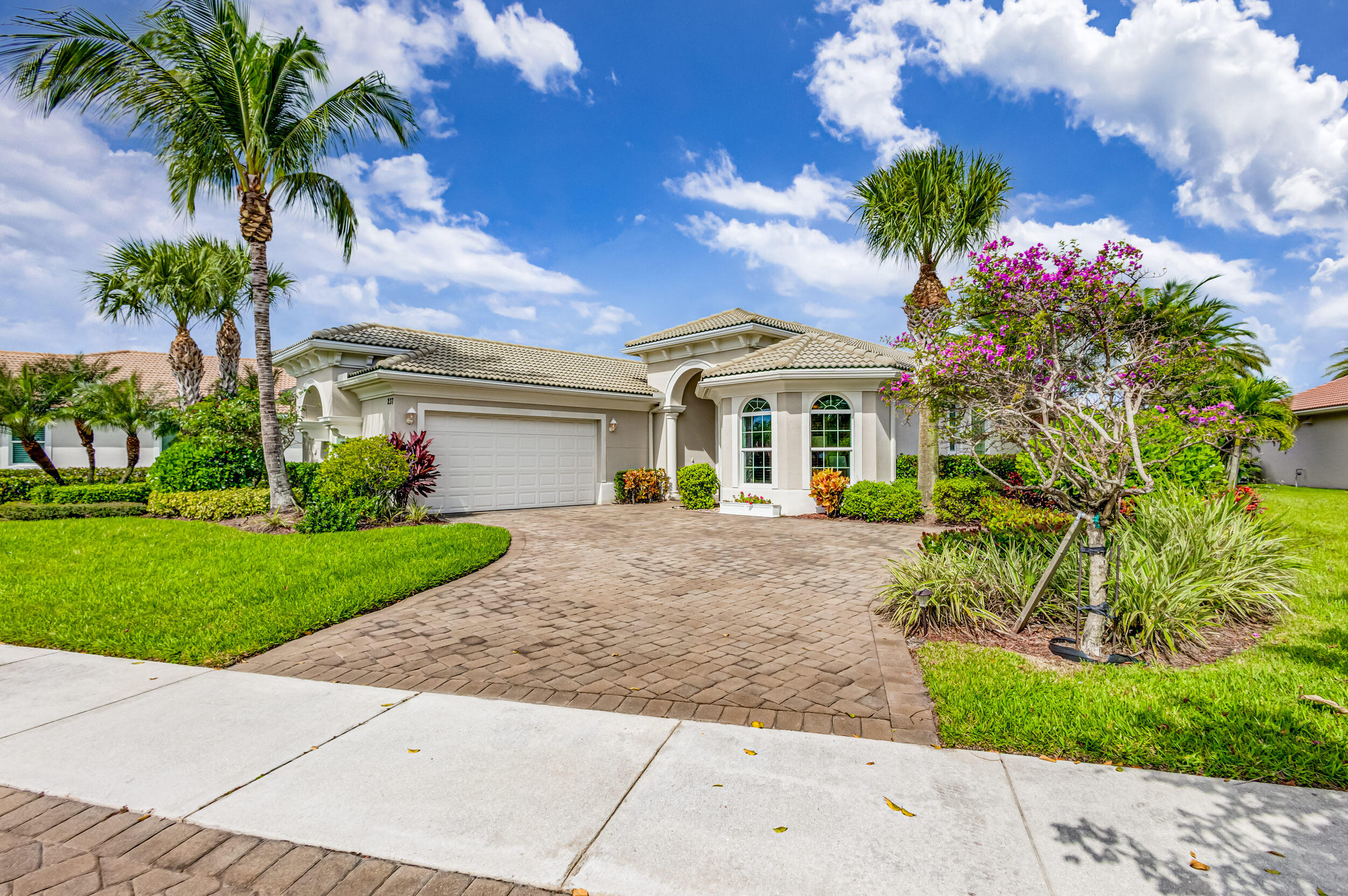 237 Carina Drive Jupiter, FL 33478 - Photo 14 of 73 a front view of a house with a garden
