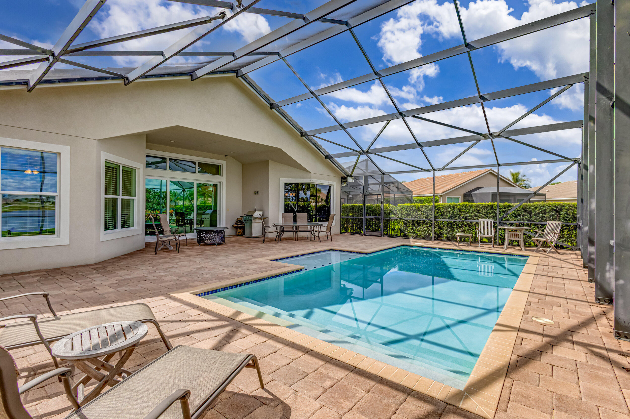 237 Carina Drive Jupiter, FL 33478 - Photo 17 of 73 a view of a patio with a dining table and chairs under an umbrella