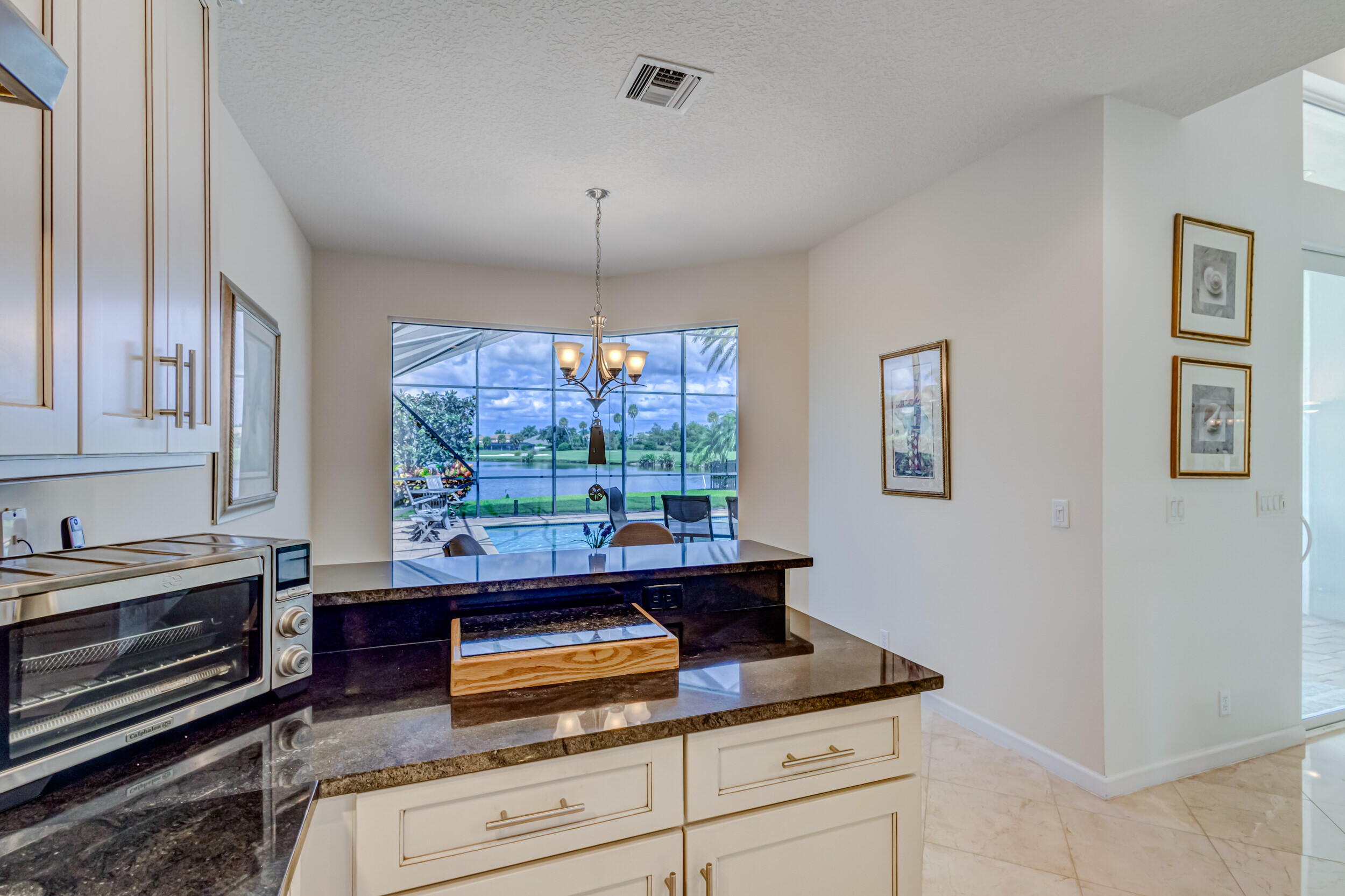 237 Carina Drive Jupiter, FL 33478 - Photo 25 of 73 a kitchen with kitchen island granite countertop a stove and a wooden floors