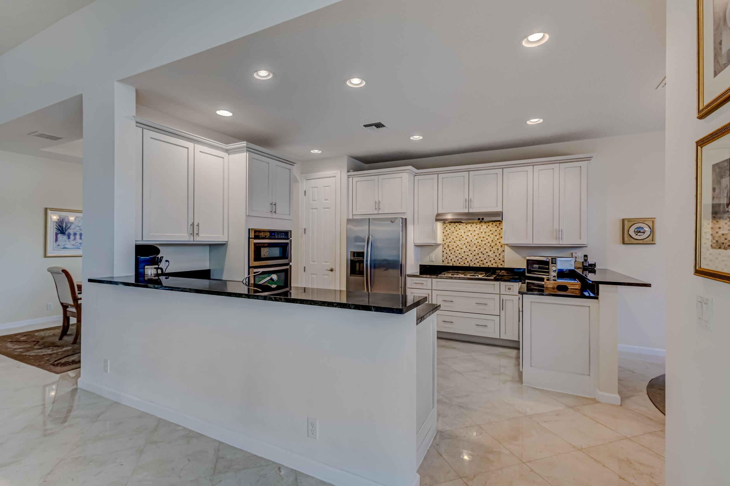 237 Carina Drive Jupiter, FL 33478 - Photo 35 of 73 a kitchen with granite countertop a sink and white cabinets