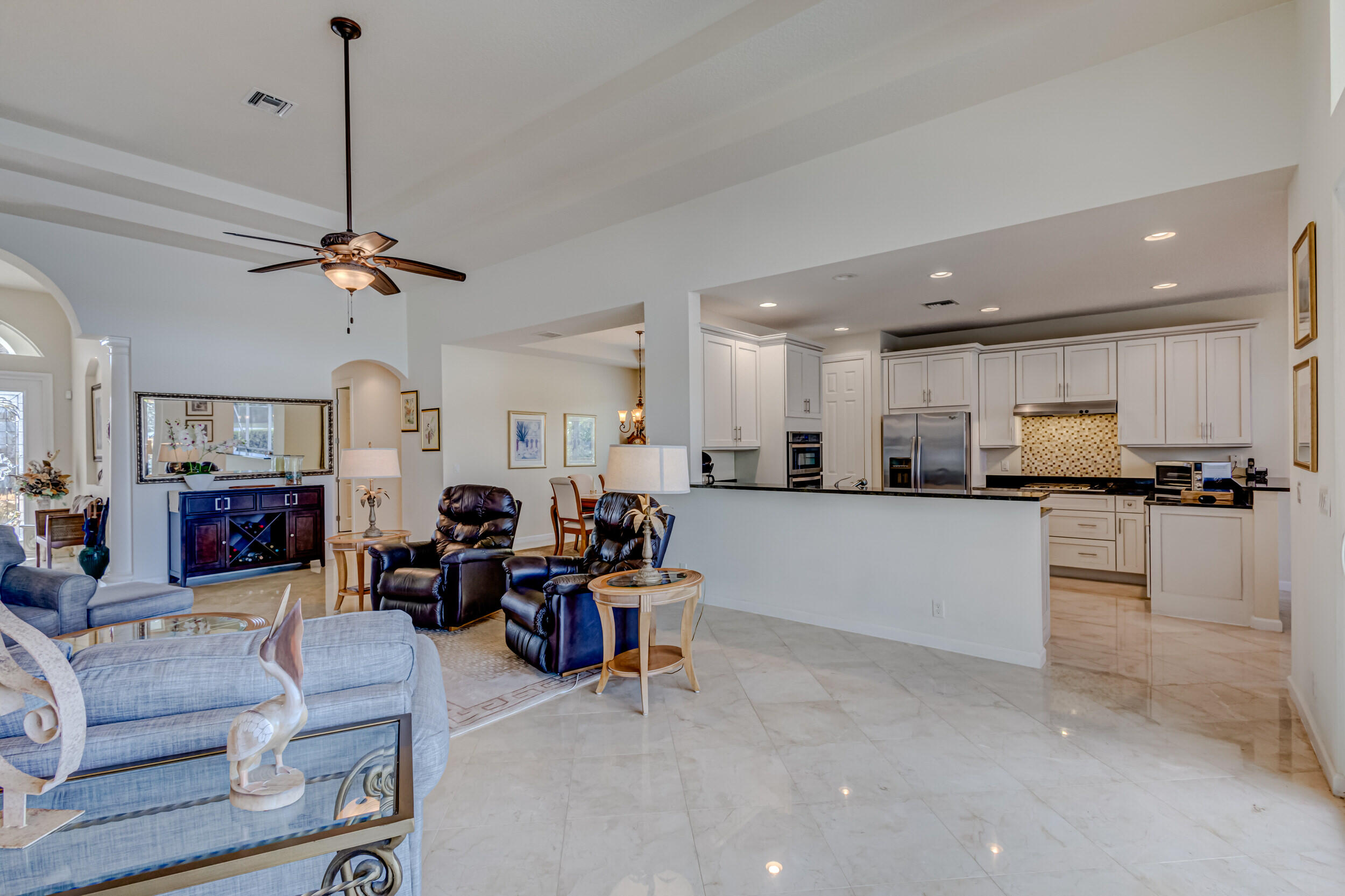 237 Carina Drive Jupiter, FL 33478 - Photo 59 of 73 a living room with furniture kitchen view and a chandelier