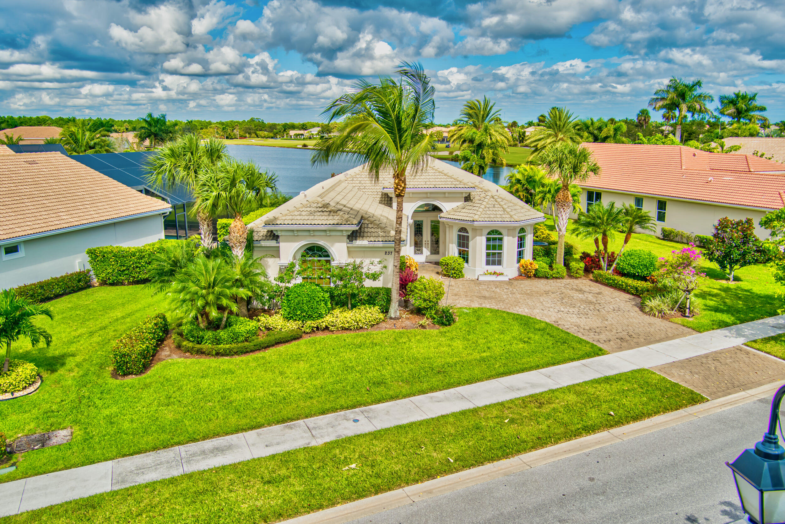 237 Carina Drive Jupiter, FL 33478 - Photo 9 of 73 a front view of a house with a yard and potted plants