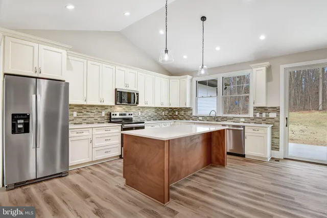 a kitchen with granite countertop white cabinets white stainless steel appliances with a sink and dishwasher