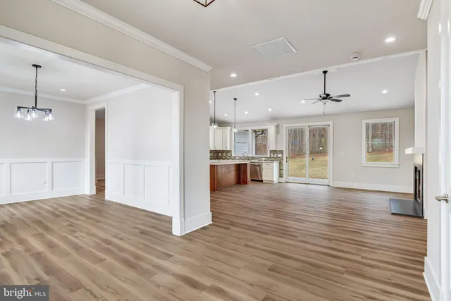 a large kitchen with stainless steel appliances kitchen island a large counter top and wooden floors