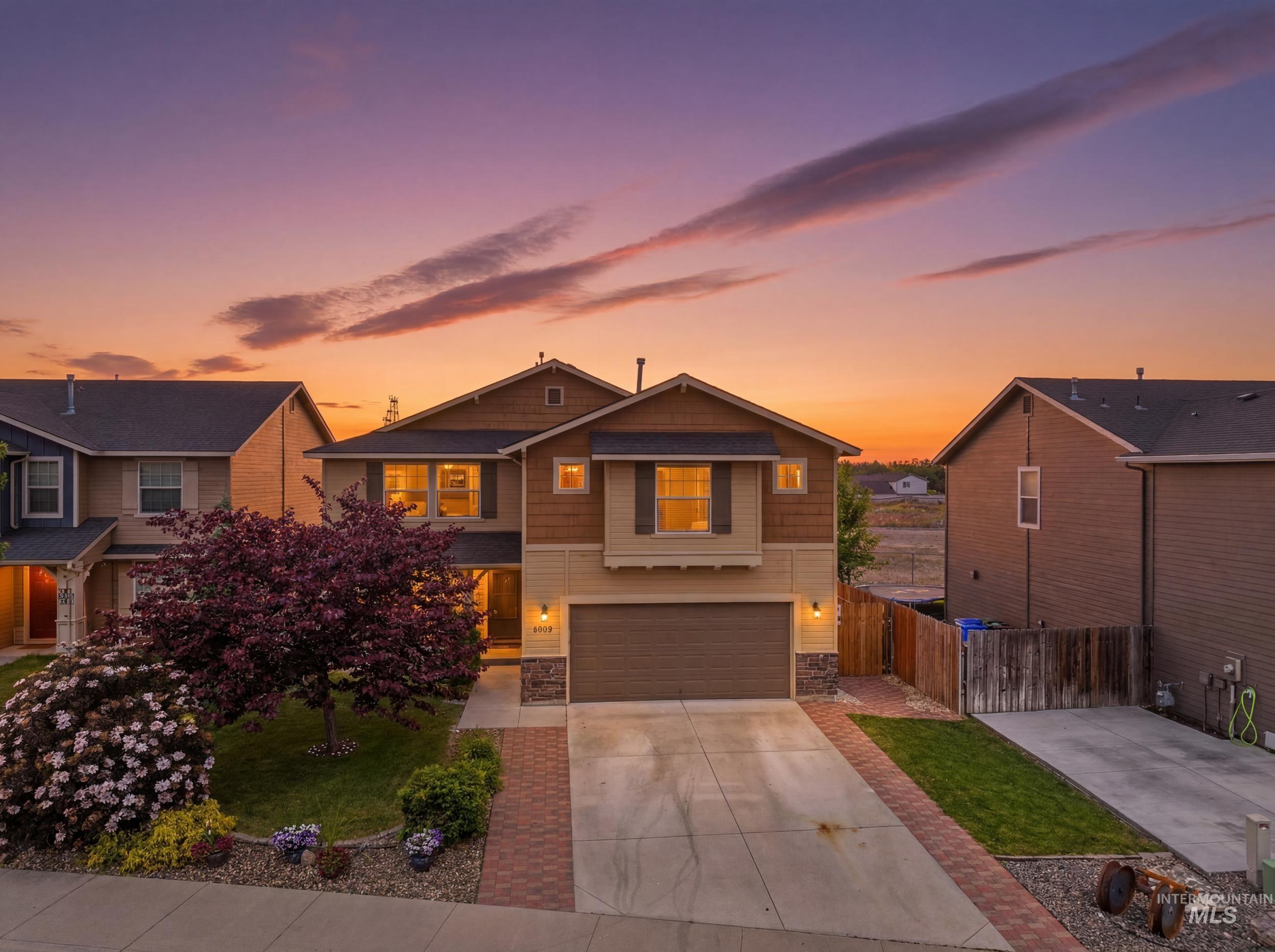 4855 South Chex Way Boise, ID 83709 - Photo 1 of 47 Two-story residential exterior featuring a two-car garage, brick paver accents, and a mature flowering tree