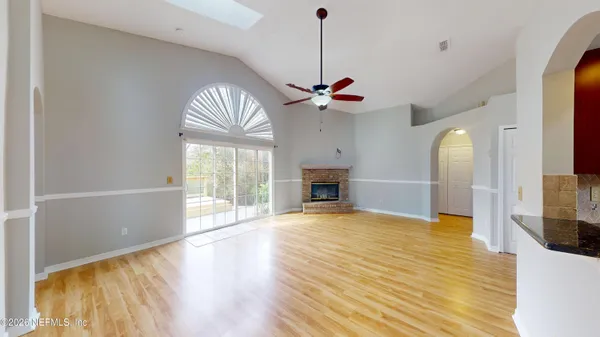 a view of an empty room with a fireplace and a window