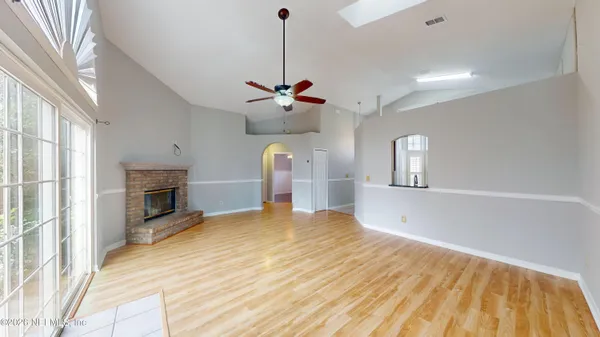 a view of a big room with wooden floor and windows