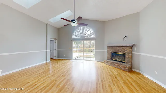 a view of an empty room with a fireplace and a window
