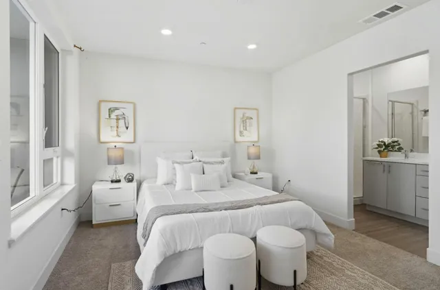 a bedroom with a white bed and a table