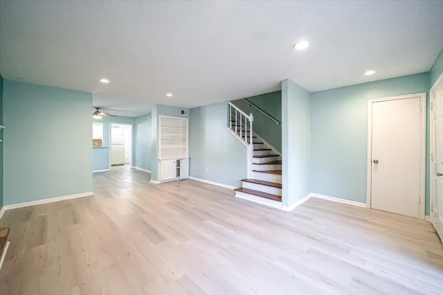 a view of empty room with wooden floor and window