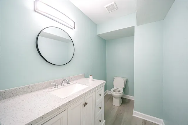 a bathroom with a granite countertop sink mirror and a toilet