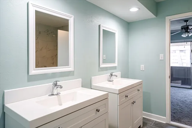a bathroom with double sink and two mirror