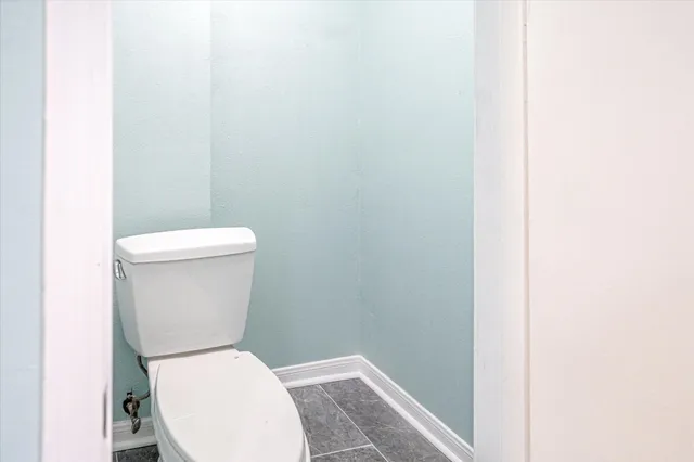 a white toilet sitting next to a white wall