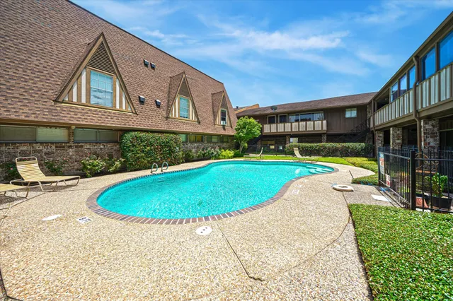a view of a swimming pool with a yard and plants