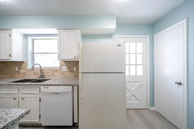 a kitchen with a sink a window and cabinets