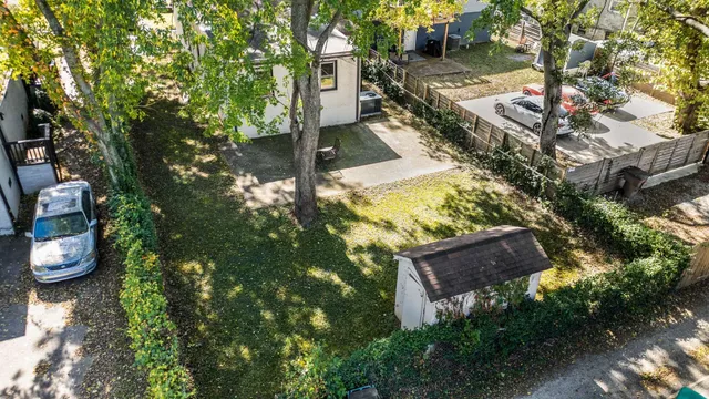 a backyard of a house with table and chairs and a large tree