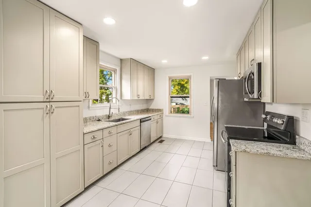a kitchen with a refrigerator sink and cabinets