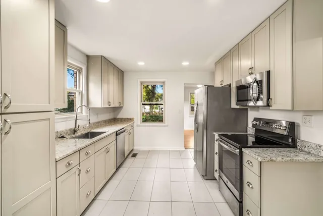 a kitchen with stainless steel appliances granite countertop a sink and a refrigerator