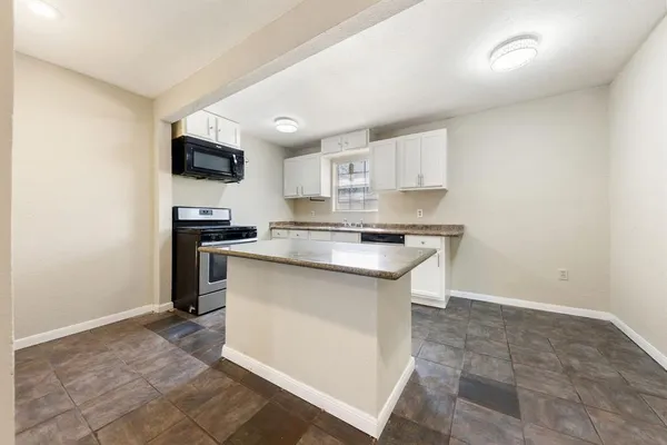 a kitchen with granite countertop a stove and a refrigerator
