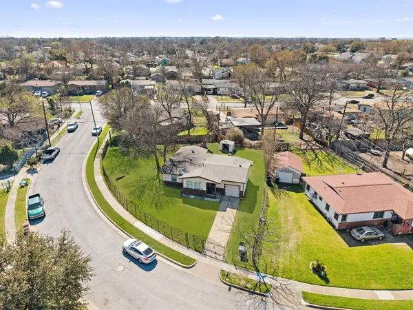 an aerial view of a swimming pool with a yard and seating area
