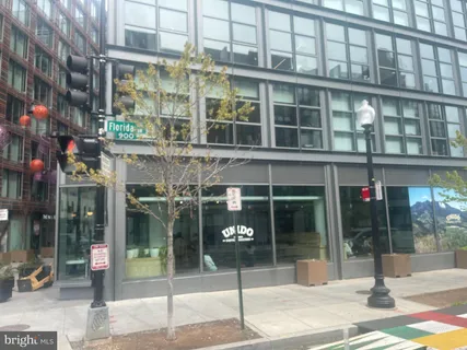 a view of a brick house with large windows and a small yard