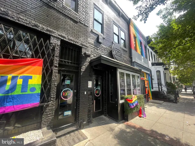 a front view of multi story residential apartment building with retail shops