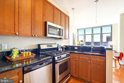 a kitchen with stainless steel appliances granite countertop a sink stove and cabinets