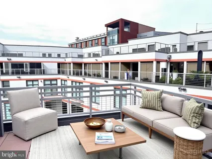 a view of a patio with couches chairs and wooden floor