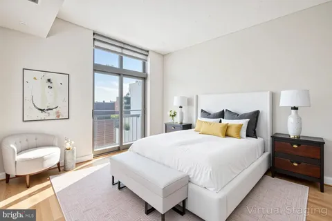 a spacious bedroom with a bed and glass window