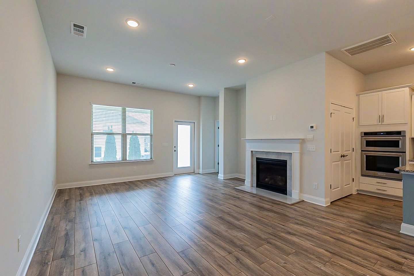 1001 Lonergan Circle Spring Hill, TN 37174 - Photo 3 of 38 an empty room with wooden floor fireplace and windows