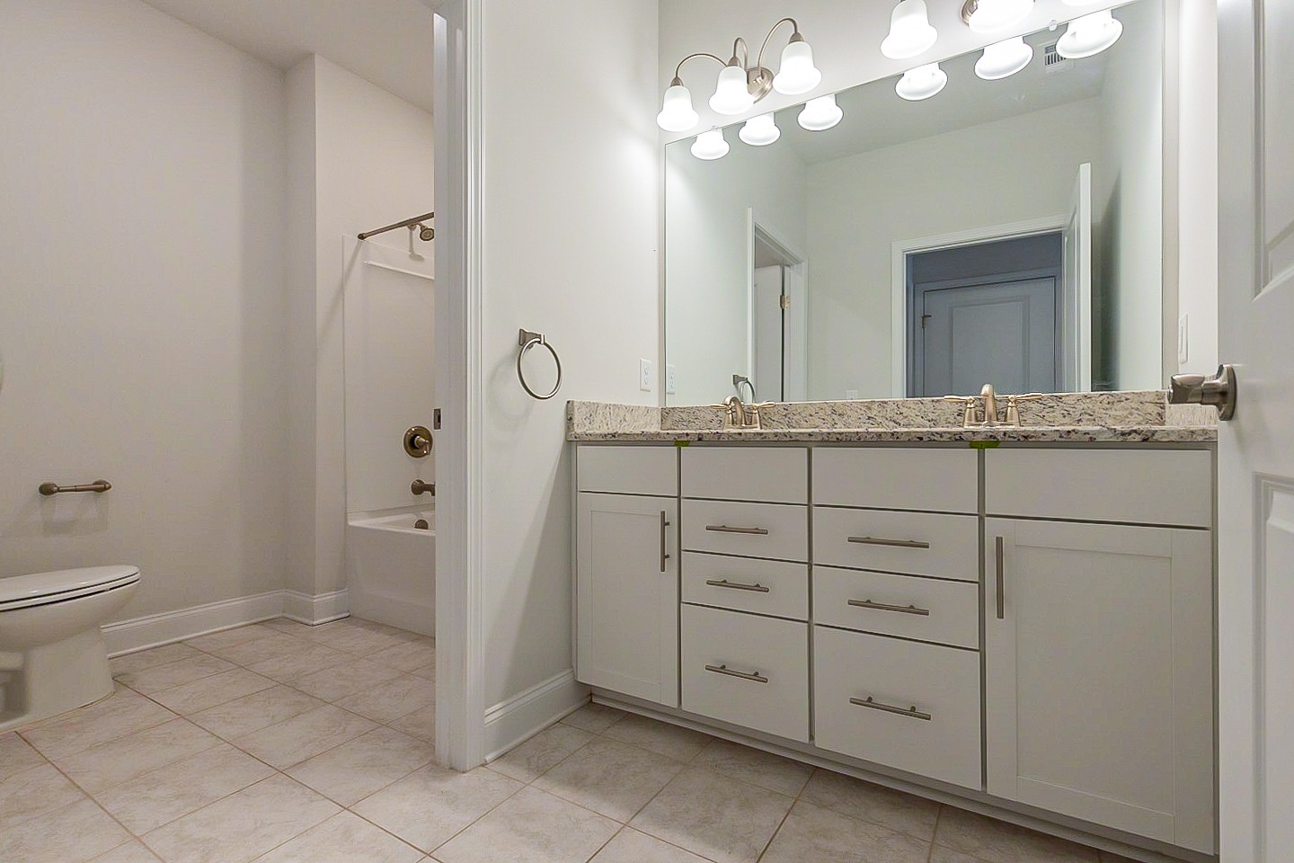 1001 Lonergan Circle Spring Hill, TN 37174 - Photo 31 of 38 a bathroom with a granite countertop sink a toilet and a mirror