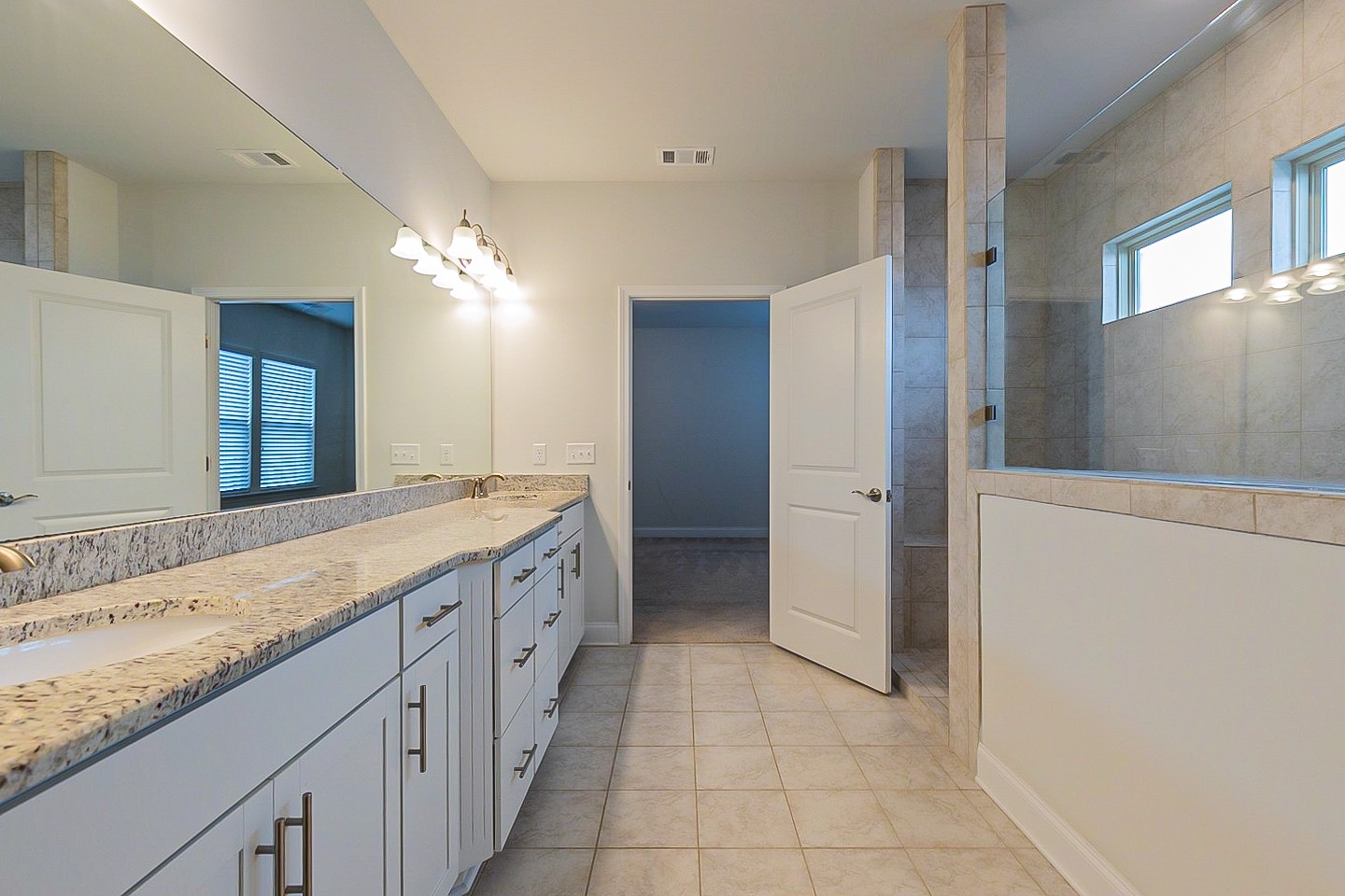1001 Lonergan Circle Spring Hill, TN 37174 - Photo 32 of 38 a spacious bathroom with a granite countertop sink a mirror and a shower